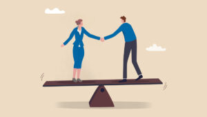 Two colleagues shaking hands on a balance seesaw