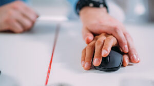Two hands on a mouse