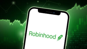Robinhood logo on a phone with a trading graphic in the background